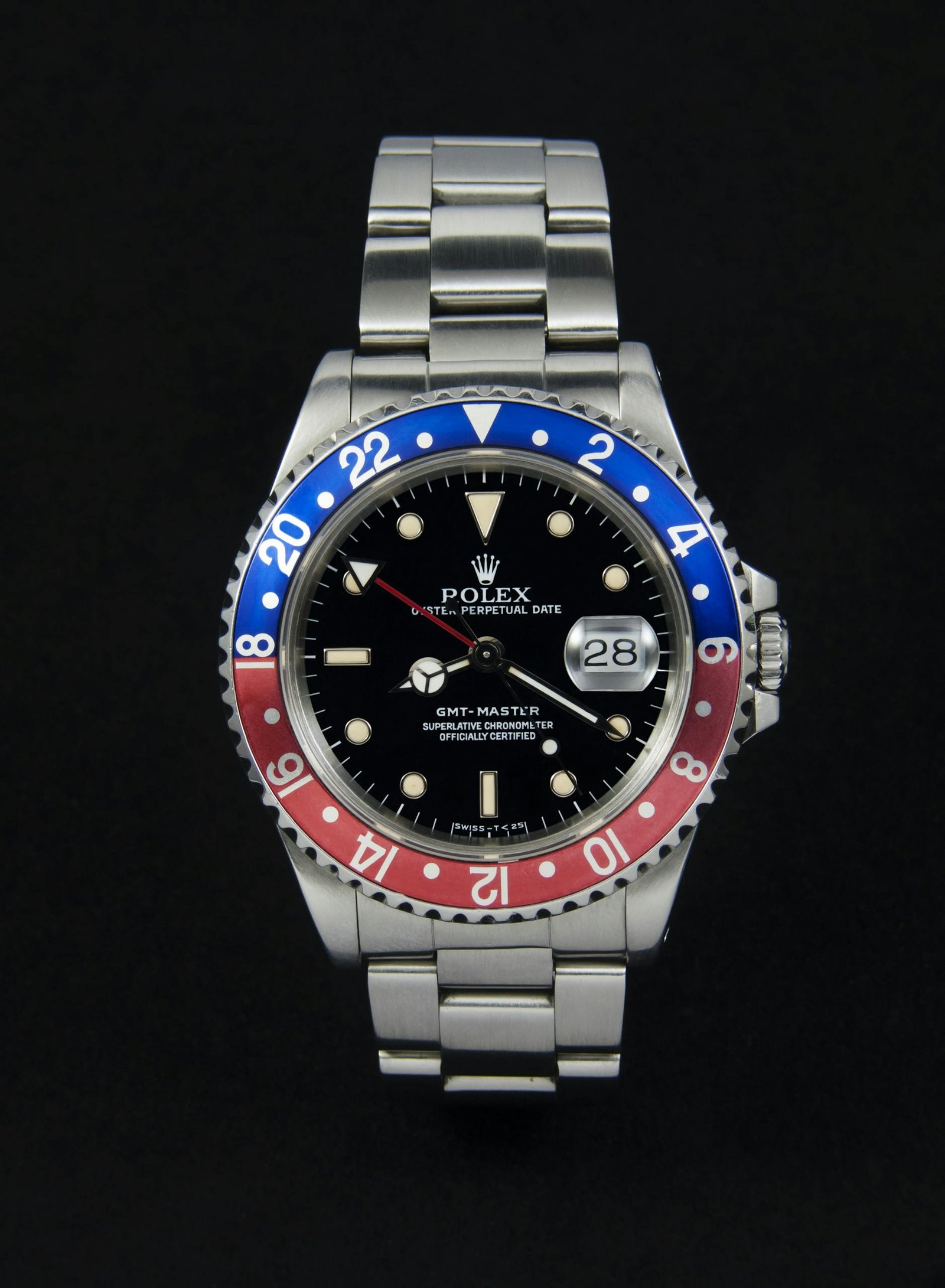 High-end stainless steel watch with dual tone bezel and date display on a dark background.